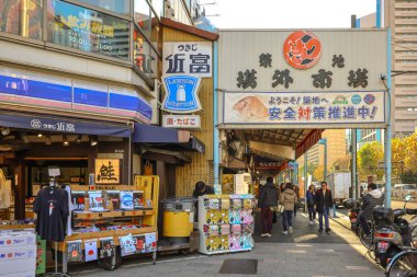 7 Aralık 2024 'te Tsukiji' nin hareketli bir pazar caddesinde dükkanlar ve tezgahlar