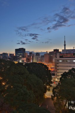 10 Aralık 2024 şehir manzarası alacakaranlık gökyüzüne karşı mimari siluetler sergiliyor, gece ve gündüz harmanlanıyor..
