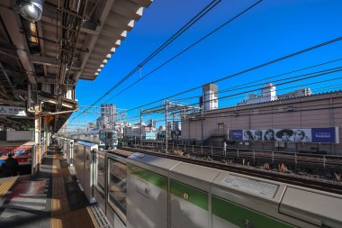 10 Aralık 2024 Önplanda demiryolu bulunan işlek şehir manzarası,