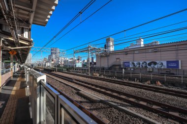 10 Aralık 2024 Önplanda demiryolu bulunan işlek şehir manzarası,