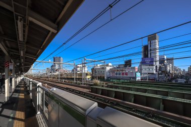 10 Aralık 2024 Önplanda demiryolu bulunan işlek şehir manzarası,