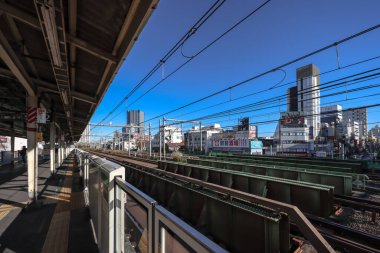 10 Aralık 2024 Önplanda demiryolu bulunan işlek şehir manzarası,