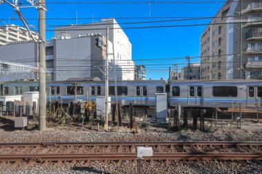 9 Aralık 2024 mavi ve gümüş tren tren rayları boyunca ilerliyor.