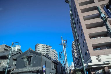 9 Aralık 2024 Tabelalı binaların bulunduğu hareketli bir şehir manzarası.