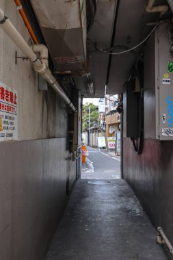 8 Aralık 2024, çeşitli tabelalar ve yapılarla süslenmiş bir sokağa açılıyor.