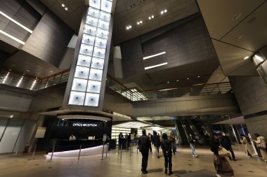 İçinde 5 Aralık 2024 tarihli cam panel bulunan modern bir ofis binasının geniş lobisi.