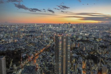 6 Aralık 2024 günbatımında bir metropolün hava görüntüsü, canlı ışıkları gösteriyor.