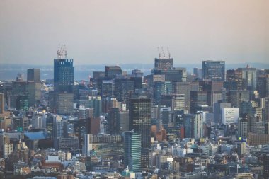 Yumuşak renkler altında çağdaş yüksek binaların yer aldığı 6 Aralık 2024 kentsel siluet