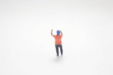 Küçük bir figür sevinçle el sallıyor.,