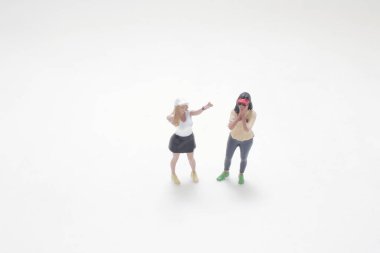 İki kadın oyuncağı, biri tutkuyla el kol hareketi yapıyor.