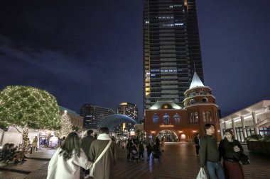 Çok güzel aydınlatılmış bir şehir meydanının manzarası. İnsanlar 7 Aralık 2024 'te geziniyor.