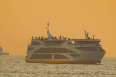 Günbatımında sakin sularda zarif bir şekilde yüzen 18 Ocak 2025 modern feribot.,