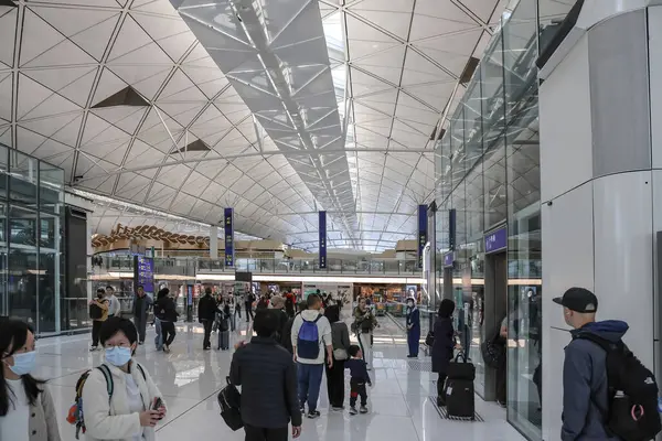 22 Mart 2025 Yolcular parlak ışıklandırmalı lüks ve modern bir havaalanı terminalinden geçecekler.