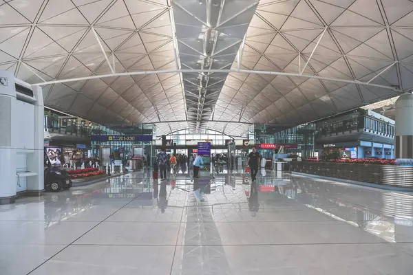 22 Mart 2025 Yolcular parlak ışıklandırmalı lüks ve modern bir havaalanı terminalinden geçecekler.