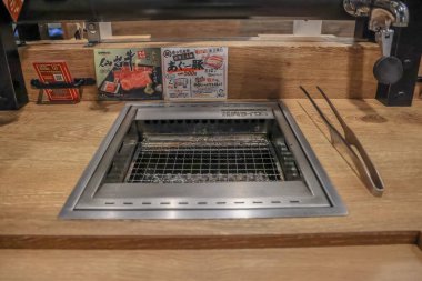 Restoranda bir masa üstü ızgarası, içinde metal ızgara var.,