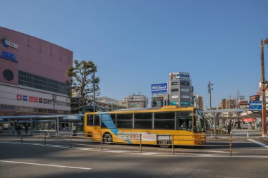 23 Mart 2025 Canlı sarı bir otobüs şehir bölgesinden geçiyor.