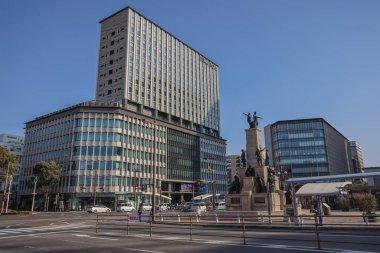 23 Mart 2025 Modern bir ofis binasının bulunduğu hareketli bir şehir merkezi.,