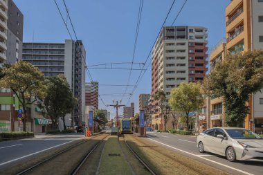 23 Mart 2025 Bir şehir manzarası yol kenarında bir tramvay gösteriyor.