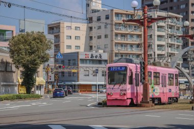 23 Mart 2025 Vibrant şehir manzarası pembe bir tramvay, apartmanların arka planı,