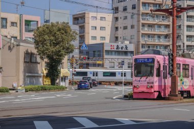 23 Mart 2025 Vibrant şehir manzarası pembe bir tramvay, apartmanların arka planı,