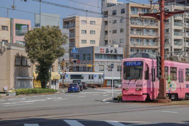 23 Mart 2025 Vibrant şehir manzarası pembe bir tramvay, apartmanların arka planı,