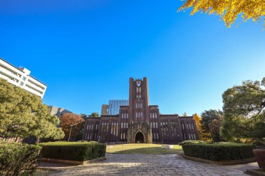 Açık gökyüzü tarafından çerçevelenmiş, saat kulesi olan akademik bina, 7 Aralık 2024