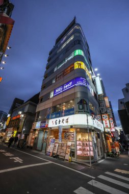 7 Aralık 2024 mağaza önü, akşam saatlerinde hareketli bir şehir ortamı yakalıyor..