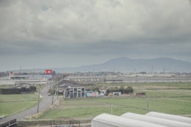 24 Mart 2025 Tarım alanları ve bulutlu bir gökyüzü altında dağınık binalar