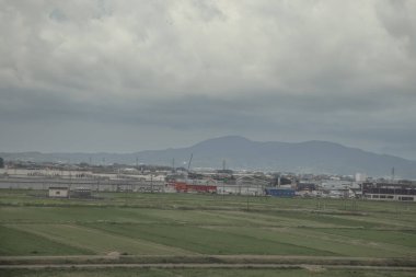 24 Mart 2025 Tarım alanları ve bulutlu bir gökyüzü altında dağınık binalar