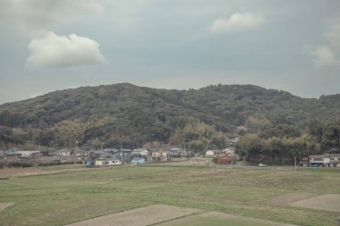 24 Mart 2025 Tarım alanları ve bulutlu bir gökyüzü altında dağınık binalar