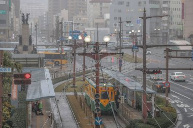 Çağdaş bir tramvay yağmurlu şehirlerde yeşil yollar boyunca seyahat ediyor.,