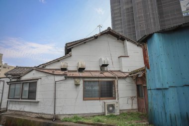 24 Mart 2025 Bir şehir bölgesinde bakımsız evleri gösteren bir sahne,