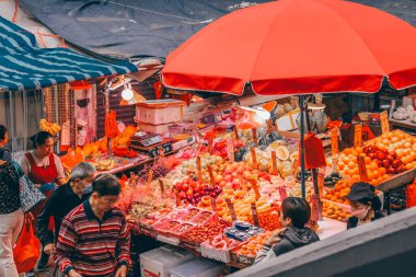 13 Nisan 2025 Yoğun sokak pazarı yüksek konut binalarıyla çevrili,