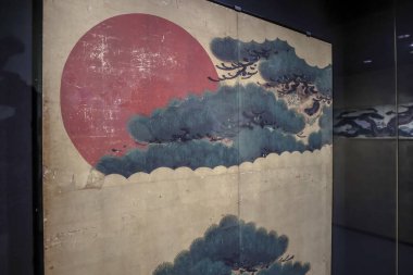 24 Mart 2025 Japon sanat paneli canlı kırmızı güneş ve yemyeşil çam dallarıyla,