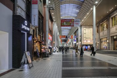 24 Mart 2025 Perakende mağazaları ve aydınlatılmış ışıkları olan geniş bir alışveriş merkezi.,