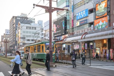 23 Mart 2025, 23 Mart 2025, Parlak sarı tramvay yaya geçidinden geçiyor.
