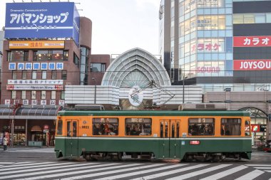 23 Mart 2025, 23 Mart 2025, Parlak sarı tramvay yaya geçidinden geçiyor.