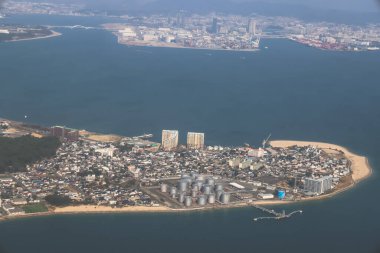 Huzurlu bir okyanusa bitişik bir kıyı şehrini sergiliyor.