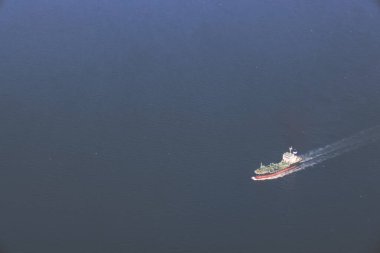 Kargo gemisi engin açık sularda sorunsuzca ilerler ve geride iz bırakır.,