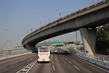 22 Mart 2025 Araçlar açık bir gökyüzü altında modern bir yükseltilmiş otoyolda yol almaktadır..