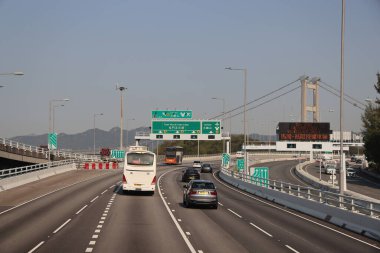 22 Mart 2025 Araçlar açık bir gökyüzü altında modern bir yükseltilmiş otoyolda yol almaktadır..