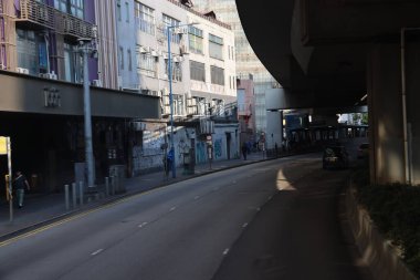 22 Mart 2025 Kırmızı otobüs durağı, araçlar, yeşillikler ve yayaların bulunduğu bir şehir caddesi.,