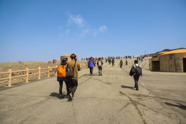 Eski toprakların yakınındaki engebeli bir arazide yürüyen bireyler,