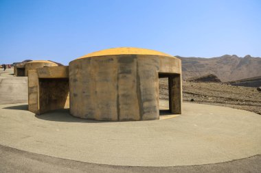 Eski toprakların yakınındaki engebeli bir arazide yürüyen bireyler,