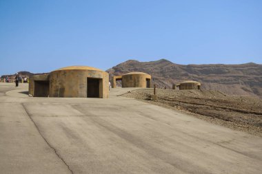 Eski toprakların yakınındaki engebeli bir arazide yürüyen bireyler,