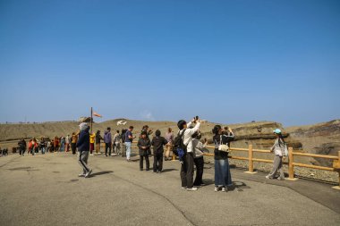 Bir grup ziyaretçi etrafındaki büyüleyici volkanik kratere hayran.