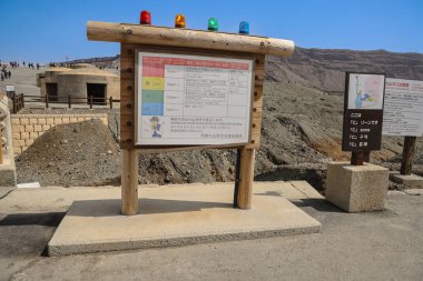 Gezginler kraterin giriş noktasının bulunduğu volkanik bir alanı ziyaret ediyorlar.,