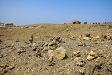 Çöl benzeri bir arazi, taşları, gezginlerle dolu, cairns olarak gösteriyor.