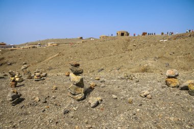 Çöl benzeri bir arazi, taşları, gezginlerle dolu, cairns olarak gösteriyor.