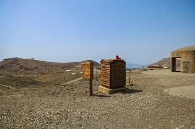Çöl sahnesinde panoramik ahşap yapılar sergileniyor.